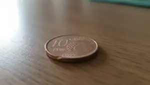 Moneta da 10 centesimi euro appoggiata su un tavolo di legno, utile per controllare un possibile errore del 2002