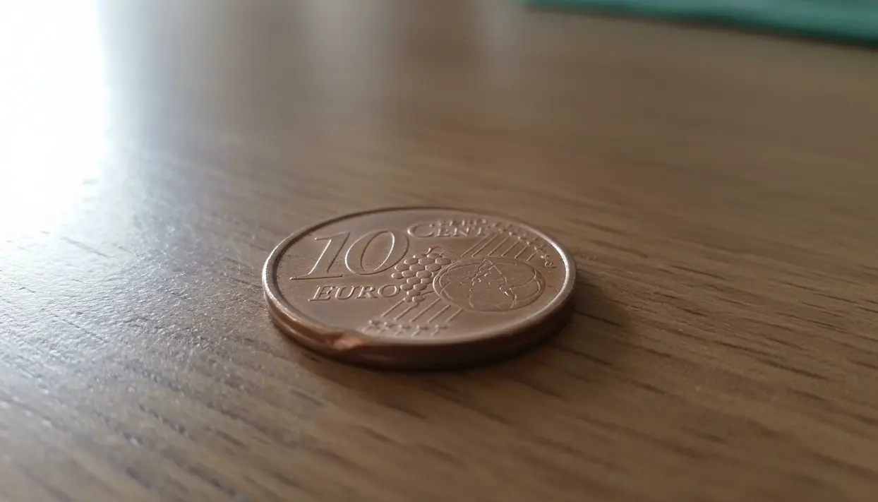 Moneta da 10 centesimi euro appoggiata su un tavolo di legno, utile per controllare un possibile errore del 2002
