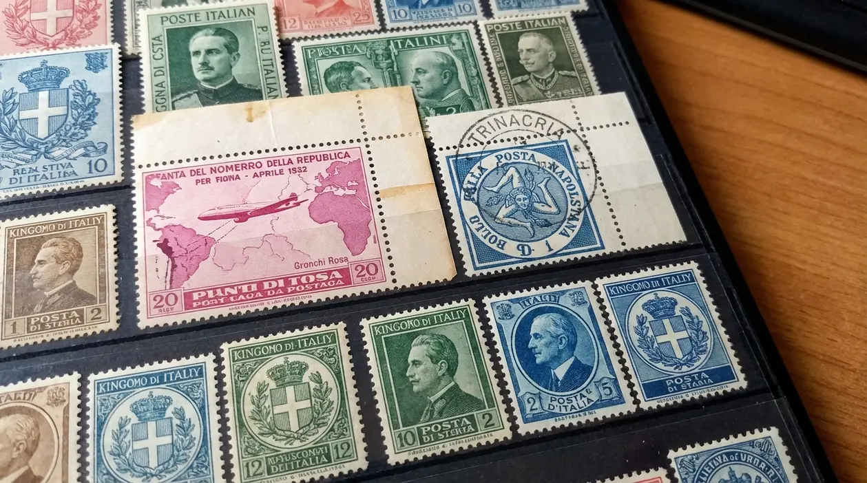 Album con francobolli italiani d’epoca, alcuni annullati, con stemmi e ritratti, su fogli neri da collezione