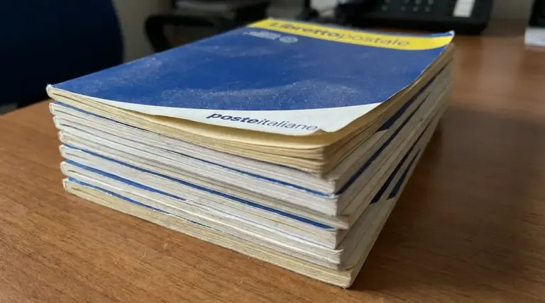 Pila di libretti postali cartacei su una scrivania, legati al tema dei libretti dormienti e dei termini di riscossione