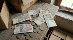 Banconote e monete in lire italiane trovate su un tavolo polveroso in soffitta, vicino a scatole di cartone